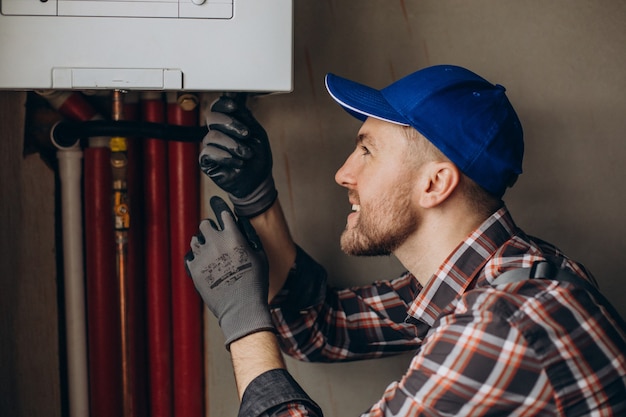 service-man-adjusting-house-heating-system_1303-26529 service-man-adjusting-house-heating-system_1303-26529